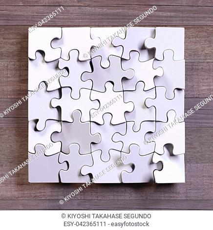 Blank puzzle in square format with wooden background. Concept of modern art using simple objects