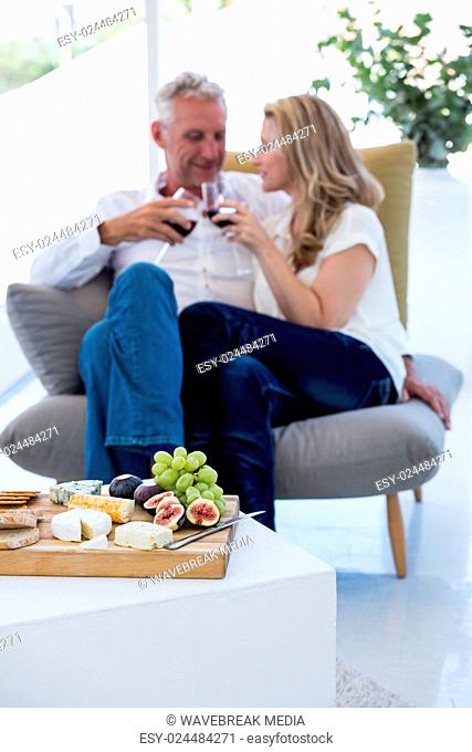 Couple toasting red wine with food