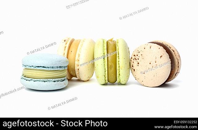 Baked round multicolored macarons on white background, close up