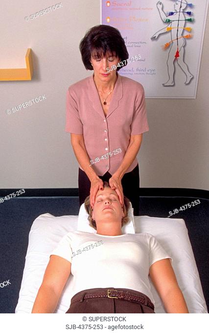 Therapist Aligning Chakra During Reiki Massage