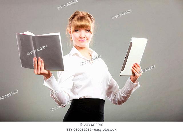 Woman learning with ebook reader and book. Choice between modern educational technology and traditional way method. Girl holding digital tablet pc and textbook