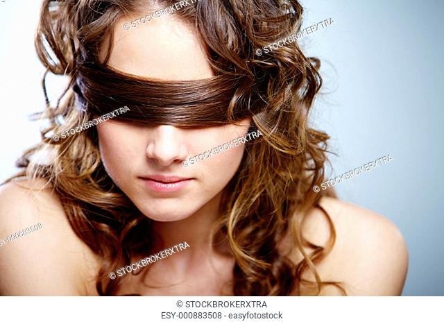 Portrait of woman covering eyes by her hair