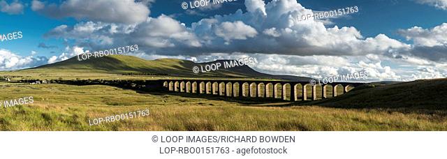 A panoramic image of the Ribblehead viaduct on a summers evening with Park Fell Simon Fell and Inglebourgh in the background