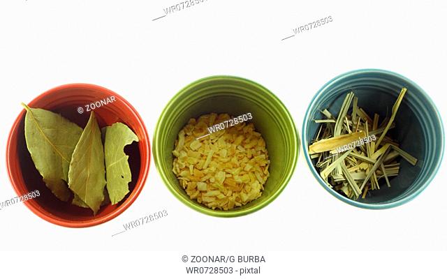 Colorful cups with herbs and spices on white background