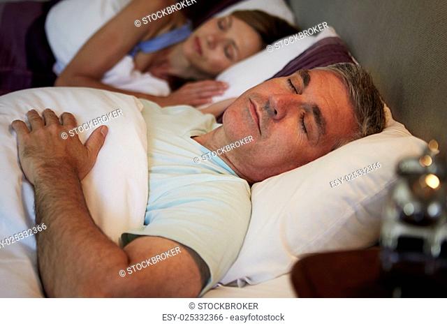 Middle Aged Couple Asleep In Bed Together