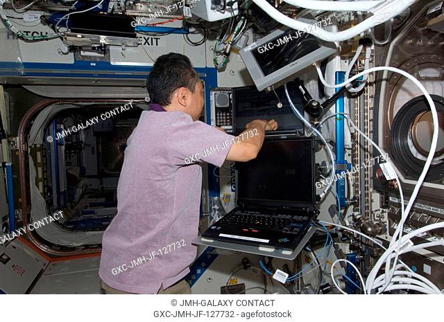 Japan Aerospace Exploration Agency astronaut Satoshi Furukawa, Expedition 28 flight engineer, uses a computer to activate the Microgravity Science Glovebox...