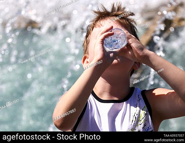 RUSSIA, MOSCOW - AUGUST 7, 2023: A boy drinks water by a fountain in Manezhnaya Square. Artyom Geodakyan/TASS