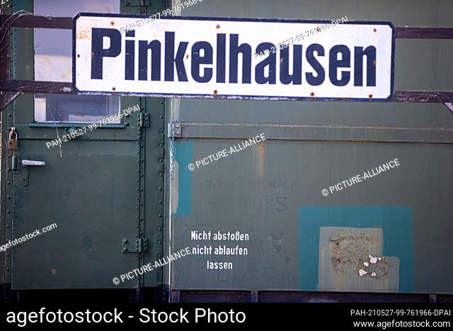 28 April 2021, Mecklenburg-Western Pomerania, Pasewalk: The sign ""Pinkelhausen"" hangs in front of the toilet wagon in the railway experience centre...