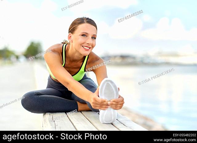 happy young woman doing sports and stretching leg