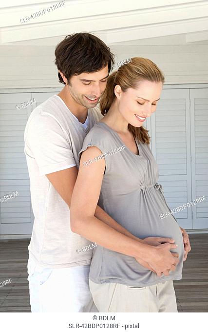 Man holding pregnant girlfriends belly