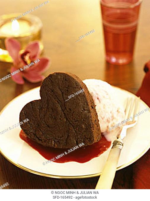 Small heart-shaped chocolate cake with ice cream & fruit sauce
