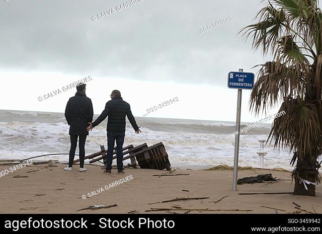 Tavernes de la Valldigna, Valencia, Spain, January 22, 2020. A couple of pedestrians watch as the sea has taken part of the beach leaving branches and algae