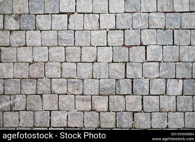 Stone pavement texture. Granite cobblestoned pavement background. Abstract background of old cobblestone pavement close-up