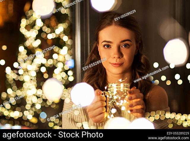 woman with christmas garland lights in glass mug