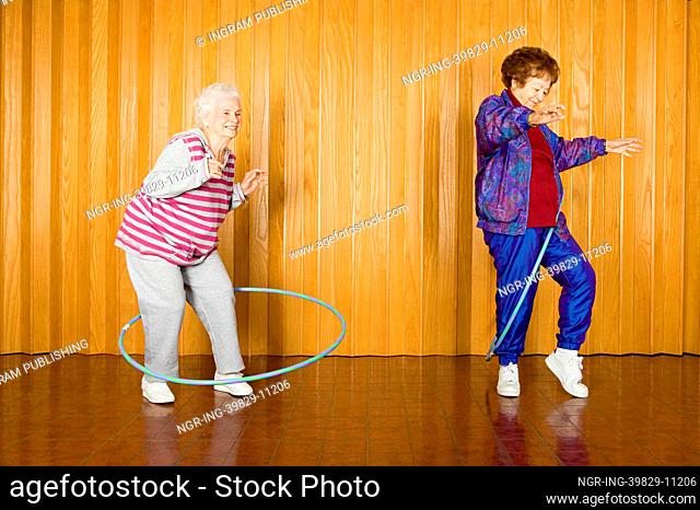 Two senior women exercising with hula hoops