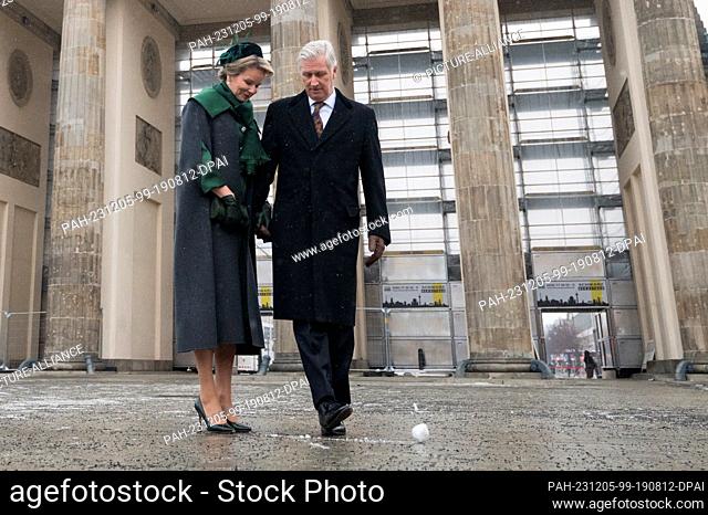 05 diciembre 2023, Berlín: El rey Felipe de Bélgica lanza una bola de nieve junto a la reina Mathilde de Bélgica en la puerta de Brandenburgo