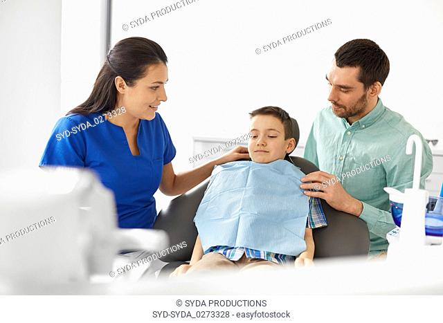 female dentist with kid patient at dental clinic