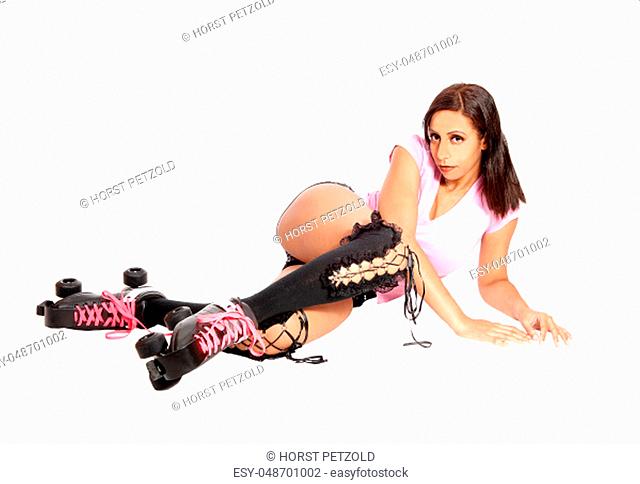 A pretty woman with roller skates and shorts lying on the floor.resting from her dance, isolated for white background