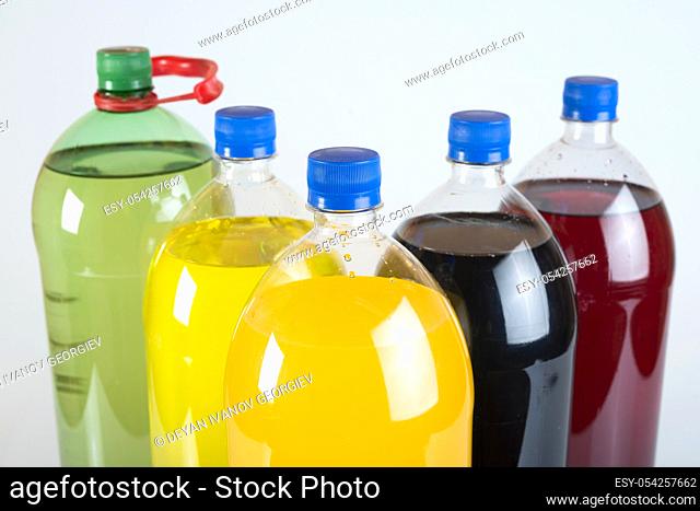 Carbonated drinks in plastic bottles. Multicolored drinks. Studio shot