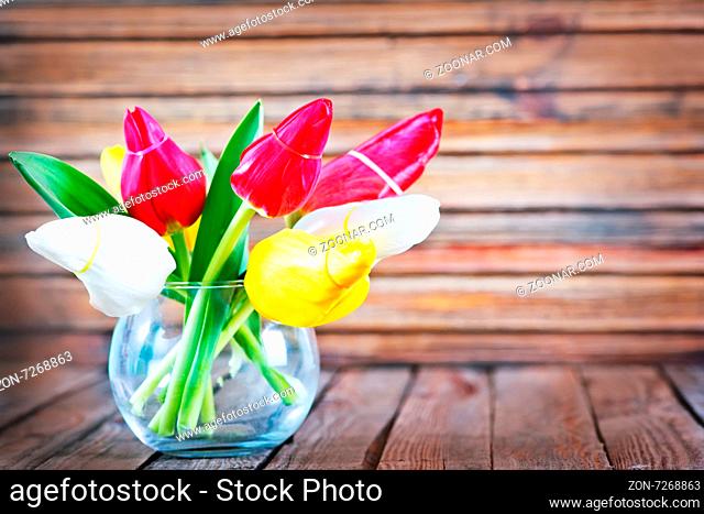 tulips in vase and on a table