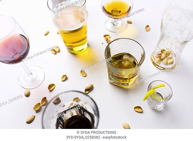 glasses of different alcohol drinks on messy table