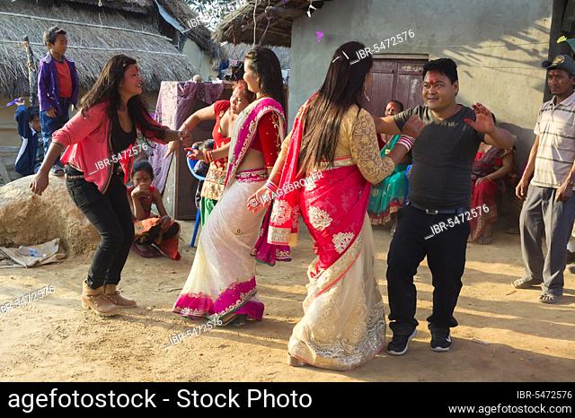 People of the Tharu ethnic group dance and laugh during a wedding, Chitwan, Nepal, Asia