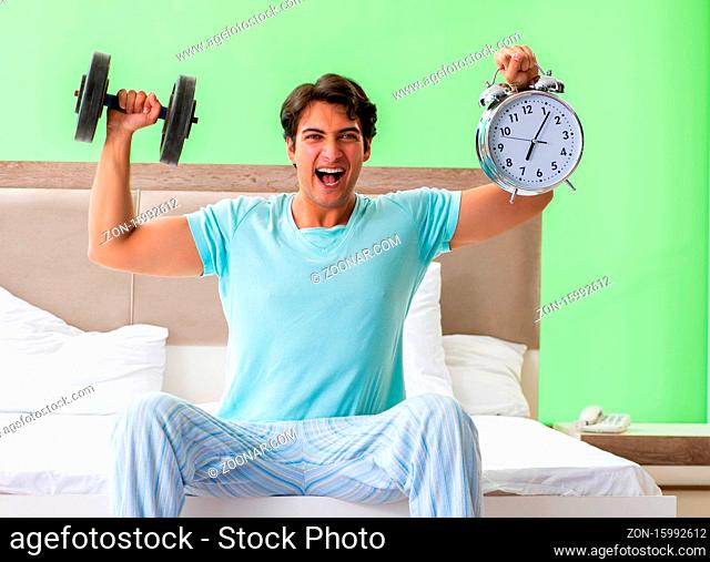 The young man in pajamas doing morning exercises