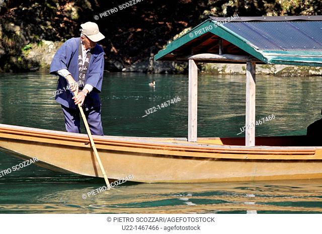 Kyoto (Japan): a sailor taking tourists on excursion on a small boat in Arashiyama