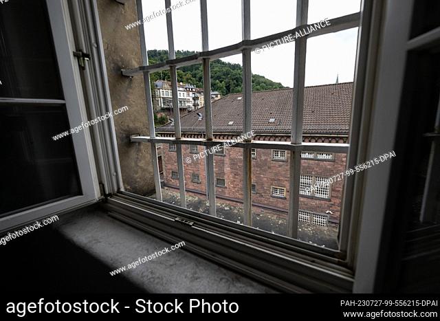 25 July 2023, Baden-Württemberg, Stuttgart: A building of the ex-prison ""Fauler Pelz"" in Heidelberg's old town can be seen through a barred window