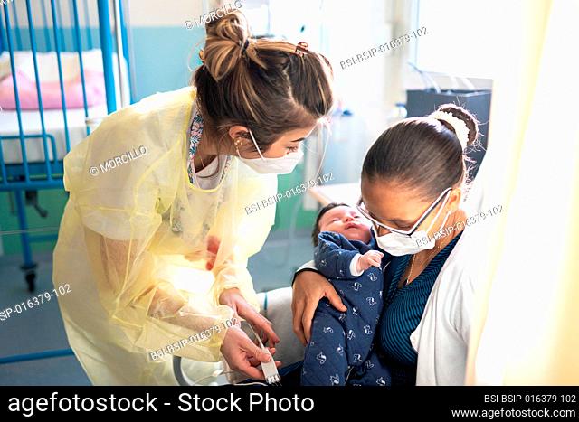 Mother and son with bronchiolitis with a nursery nurse in a hospital pediatric ward