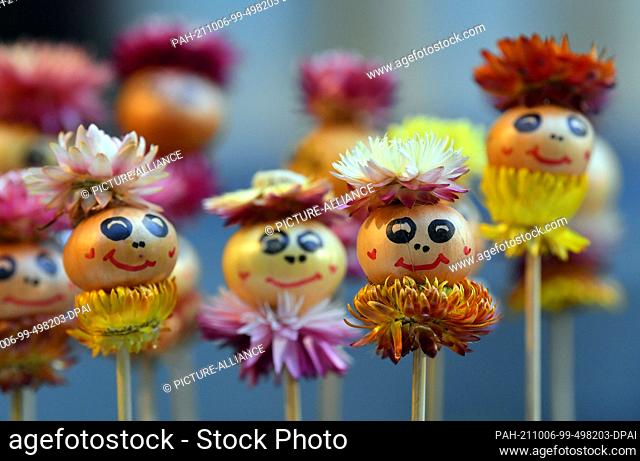 06 October 2021, Thuringia, Weimar: Small onions with painted faces stand at a market stall. The 368th Weimar Onion Market begins on October 8