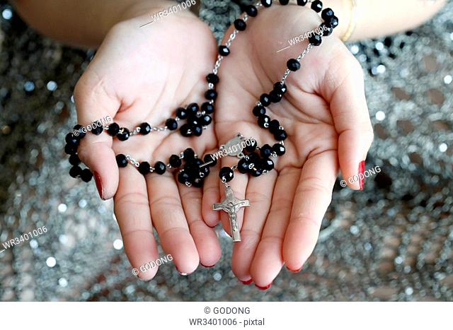 Catholic woman praying rosary beads and crucifix, Vietnam, Indochina, Southeast Asia, Asia