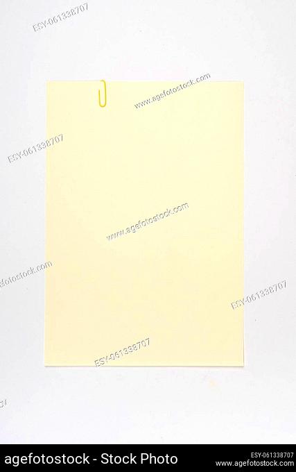 a blank sheet of suede-colored paper with a paper clip