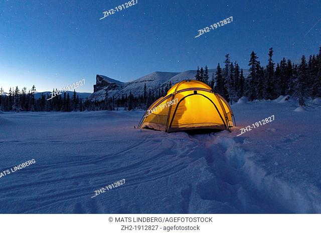 Tent in winter landscape with a shadow of a man