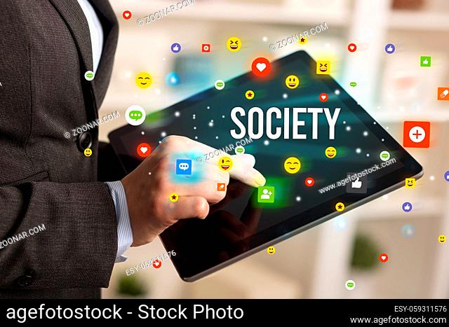 Close up of business person playing multimedia with social media icons and SOCIETY inscription