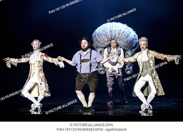 20 November 2018, Berlin: Allan Clayton (M. vorne) as Candide and Franz Hawlata as Voltaire (M. hinten) perform with dancers at the photo rehearsal of the...