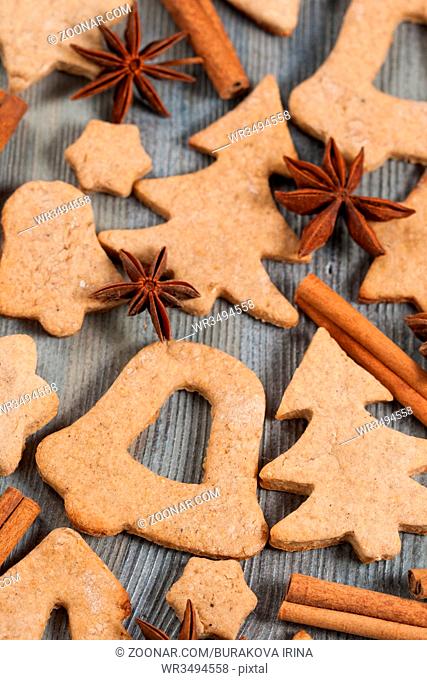 Gingerbread cookies and spices over wooden background