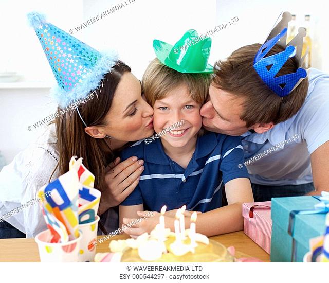 Close-up of parents celebrating their son's birthday in the kitchen