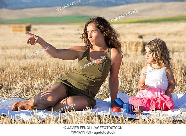 mother and daughter having a picnic in the field