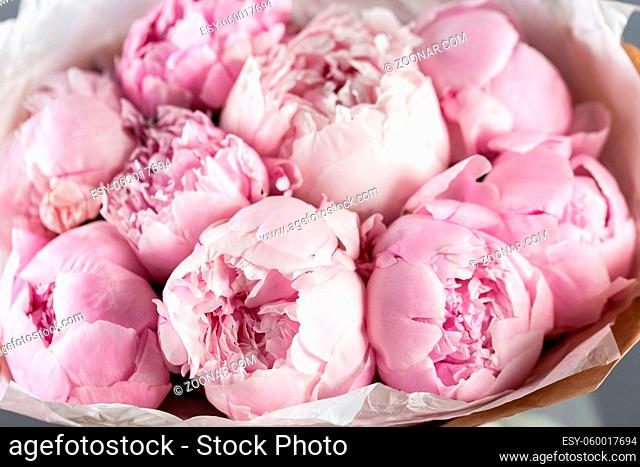 Pink peonies in vase on wooden floor and bokeh background - retro styled photo. soft focus. close-up