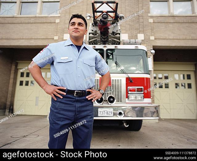 Fireman posing for the camera by fire engine
