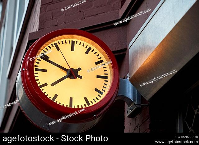 Analogue clock on a wall in an urban street