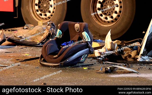25 September 2022, Lower Saxony, Bohmte: A child's seat lies on the road next to two truck tires at the scene of the accident on federal highway 51 in the...