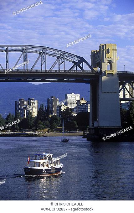 Burrard bridge frames view to West End, with small passenger ferry, Vancouver, British Columbia, Canada