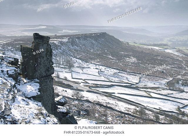 View of upland rock escarpments in snow, Curbar Edge and Baslow Edge behind, Peak District, Derbyshire, England, march