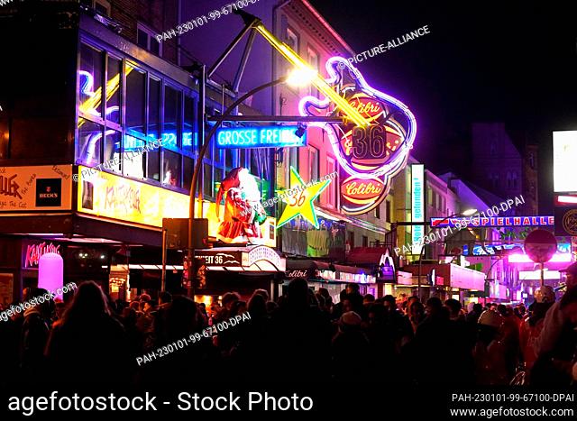 01 January 2023, Hamburg: Revelers walk across the Große Freiheit on New Year's Eve in the St. Pauli district. Photo: Marcus Brandt/dpa