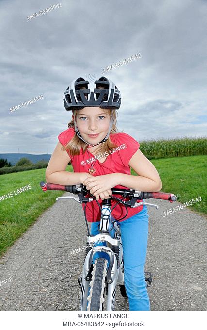 Nine-year-old girl with helmet on a bicycle