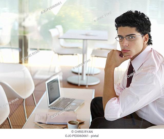 Businessman in cafeteria with laptop