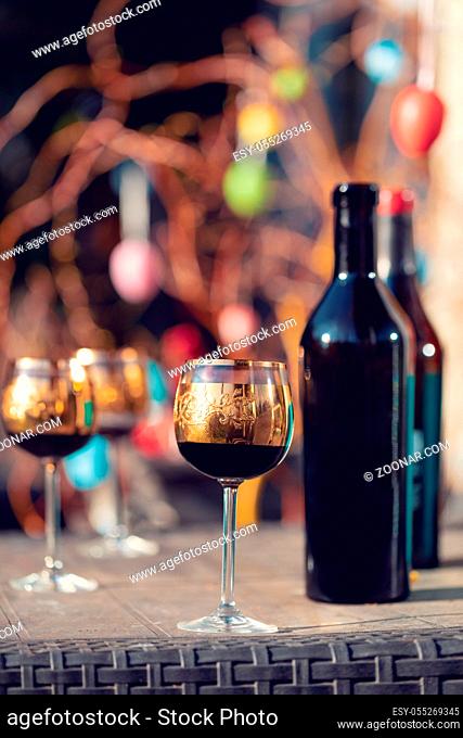 Bottle of vine, glass and easter eggs in blurry background. Spring easter concept