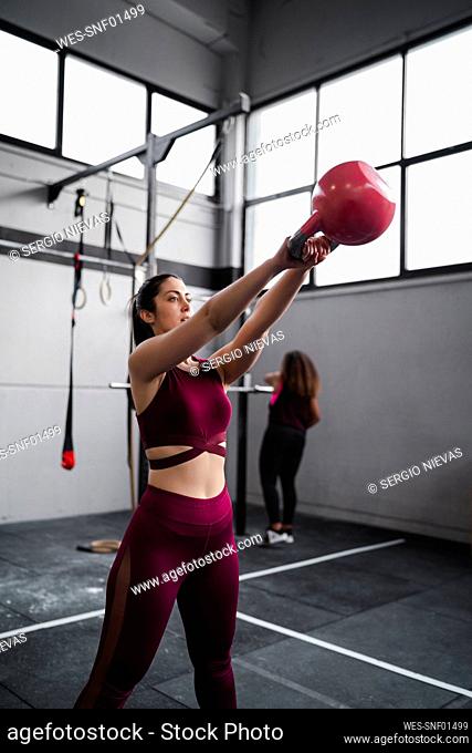 Sportswoman exercising with kettlebell at gym